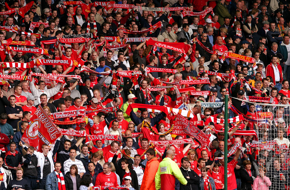 Fans of liverpool fc in football stadium in red jerseys